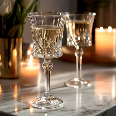Elegant crystal glasses with sparkling wine, softly lit by candles.