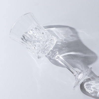 Crystal glass with intricate design, tilted to show reflections.