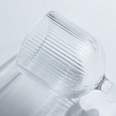 Textured clear glass cup with ribbed design.