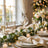 Elegant holiday dinner table with champagne, candles, and festive greenery