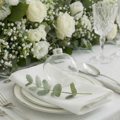 Elegant white floral wedding table setting with roses and crystal glassware