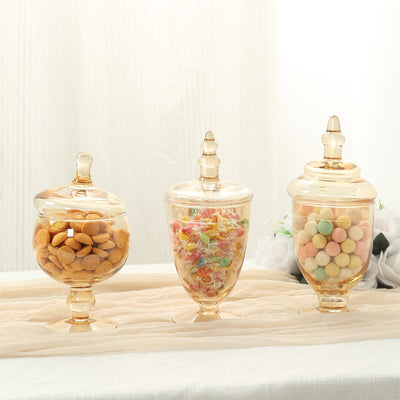 Three elegant glass jars filled with assorted candies and snacks.