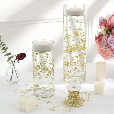 Elegant floating candles in decorative glass vases with golden accents.