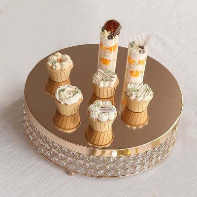 Assorted decorative cupcakes on a mirrored display stand.