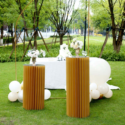 Stylish gold accent tables with floral arrangements at an outdoor event setup.
