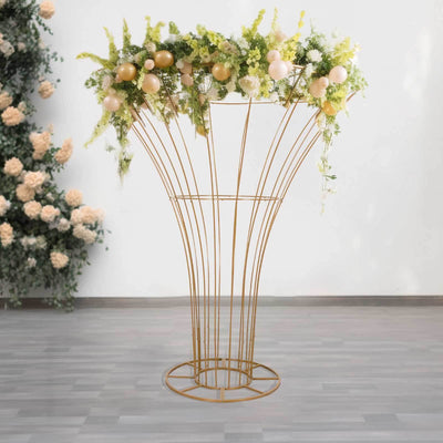 Gold floral stand adorned with greenery and balloons