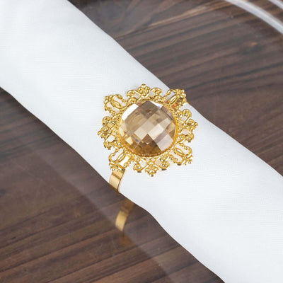 Gold ring with large faceted gemstone on a white napkin.