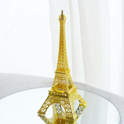 Gold Eiffel Tower replica on a reflective surface.