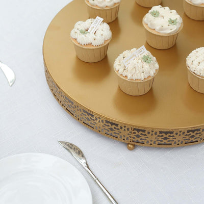 Decorative cupcakes on a gold platter with a white table setting.