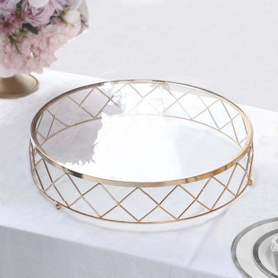 Gold geometric serving tray with a glass top on a white surface.
