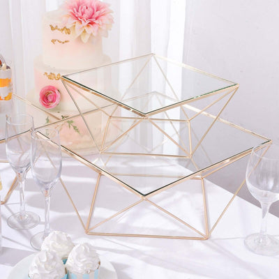 Geometric glass display stands with gold metal frames on a table.