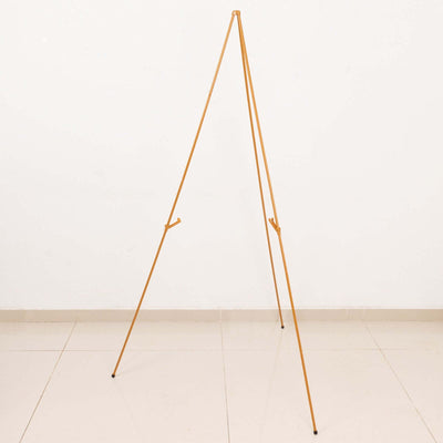 Gold tripod easel on a plain background for art display