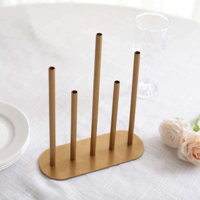 Gold metal vase holder with five tubes on a table setting.