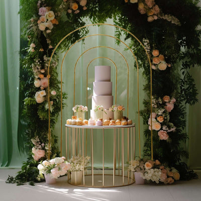 Elegant wedding cake display with floral decor and desserts on a stylish table.