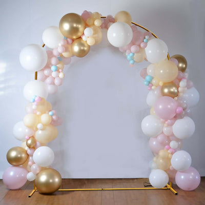 Balloon arch in pastel colors with gold accents on a plain background.