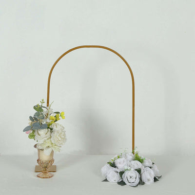 Decorative floral arch with white roses and greenery in a minimalist setting.