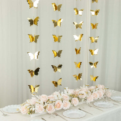 Gold butterfly decorations with pink roses on a dining table.