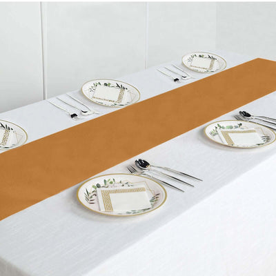 Table setting with elegant plates and a brown runner on a white tablecloth.