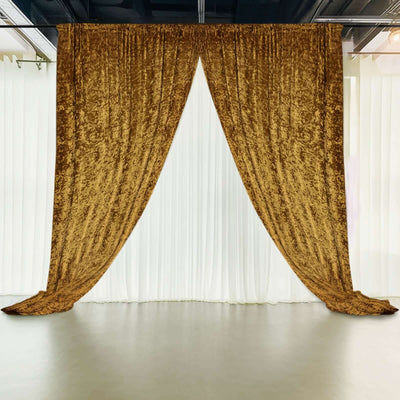 Gold velvet curtain drapes against a white backdrop in a studio setting.