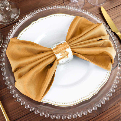 Elegant gold napkin bow on a white plate, perfect for dining decor.