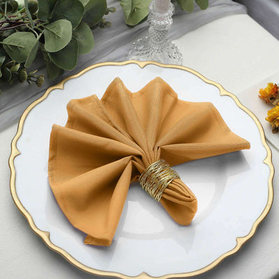 Golden cloth napkin elegantly folded on a decorative plate.