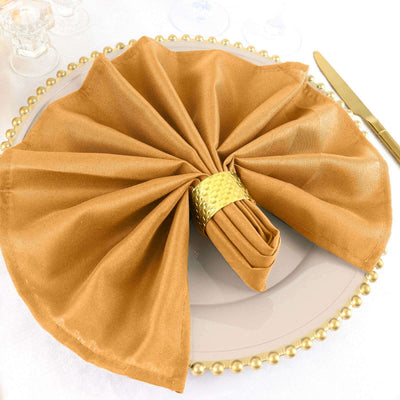 Elegant gold napkin folded on a decorative plate for stylish dining.