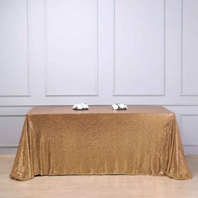 Gold sequin tablecloth draped over a table in a styled setting.