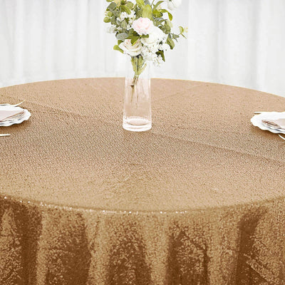 Gold sequin tablecloth on a round table with floral centerpiece.