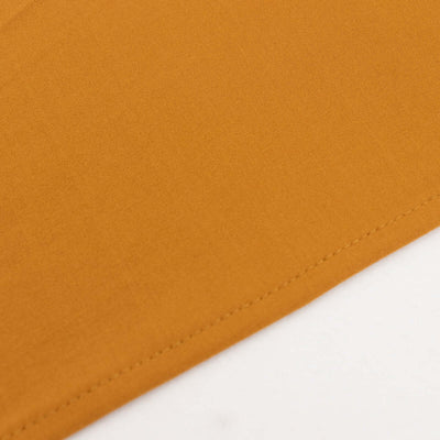 Close-up of soft mustard fabric texture with stitched edges.