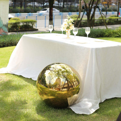Gold decorative sphere beside a table set for an outdoor event.