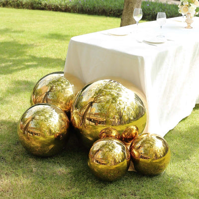 Gold decorative spheres arranged under a table in a garden setting.