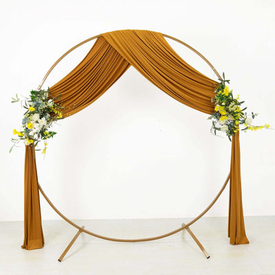 Round wedding arch with draped fabric and floral accents on a white background