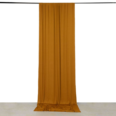 Mustard yellow draped fabric hanging from a rod against a white background