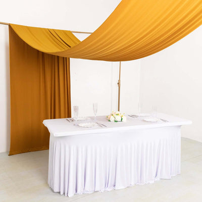 Elegant wedding table setup with draped fabric and floral centerpiece.