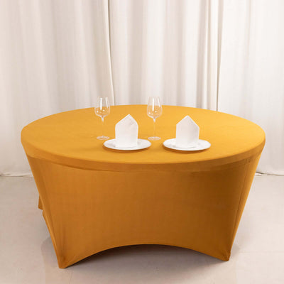 Round yellow tablecloth with white plates and glasses set for dining.
