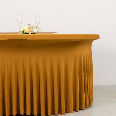 Elegant mustard tablecloth draping over a table with decorative flowers and glassware.