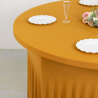 Round mustard tablecloth with white plates and decorative flowers.