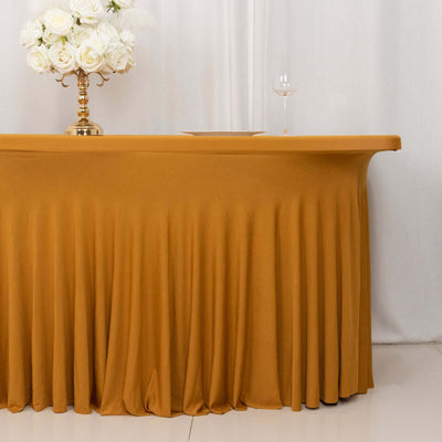 Elegant gold tablecloth draping over a table with flowers and a wine glass.