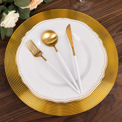 Elegant gold and white cutlery set on a decorative plate.
