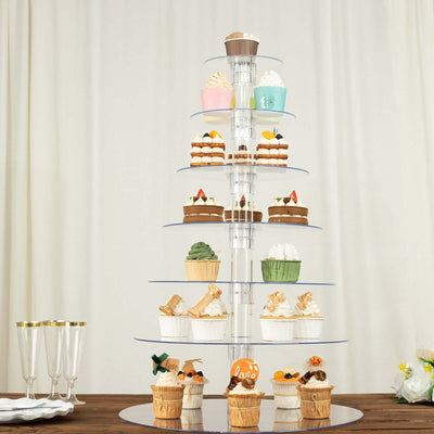 Cupcake tower display with assorted decorated cupcakes on clear tiers.