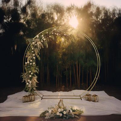 Floral wedding arch with golden accents at sunset.