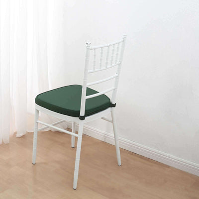 White chair with green cushion, positioned against a light background.