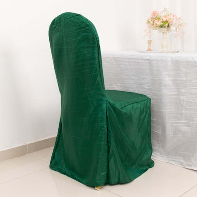 Green chair cover draped over a chair in a decorated setting.