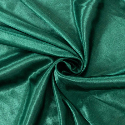 Green satin fabric texture in a swirling pattern.
