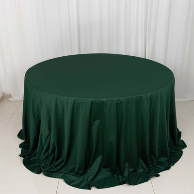 Round dark green tablecloth on a plain surface
