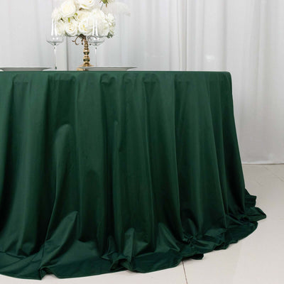 Elegant green tablecloth draping over a round table, perfect for events.
