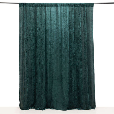 Velvet curtain in deep green color hanging against a white background