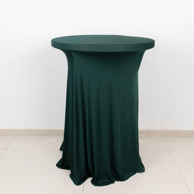 Green stretch table cover on a round table against a white backdrop