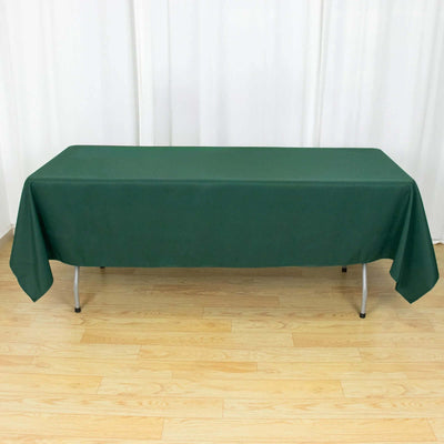 Green tablecloth draped over a folding table in a studio setting.
