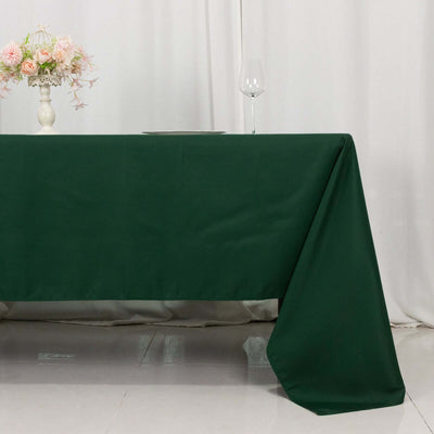 Green tablecloth draped elegantly on a table in a styled setting.